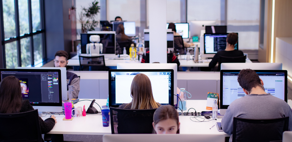 sala comercial com mesas e computadores enfileirados